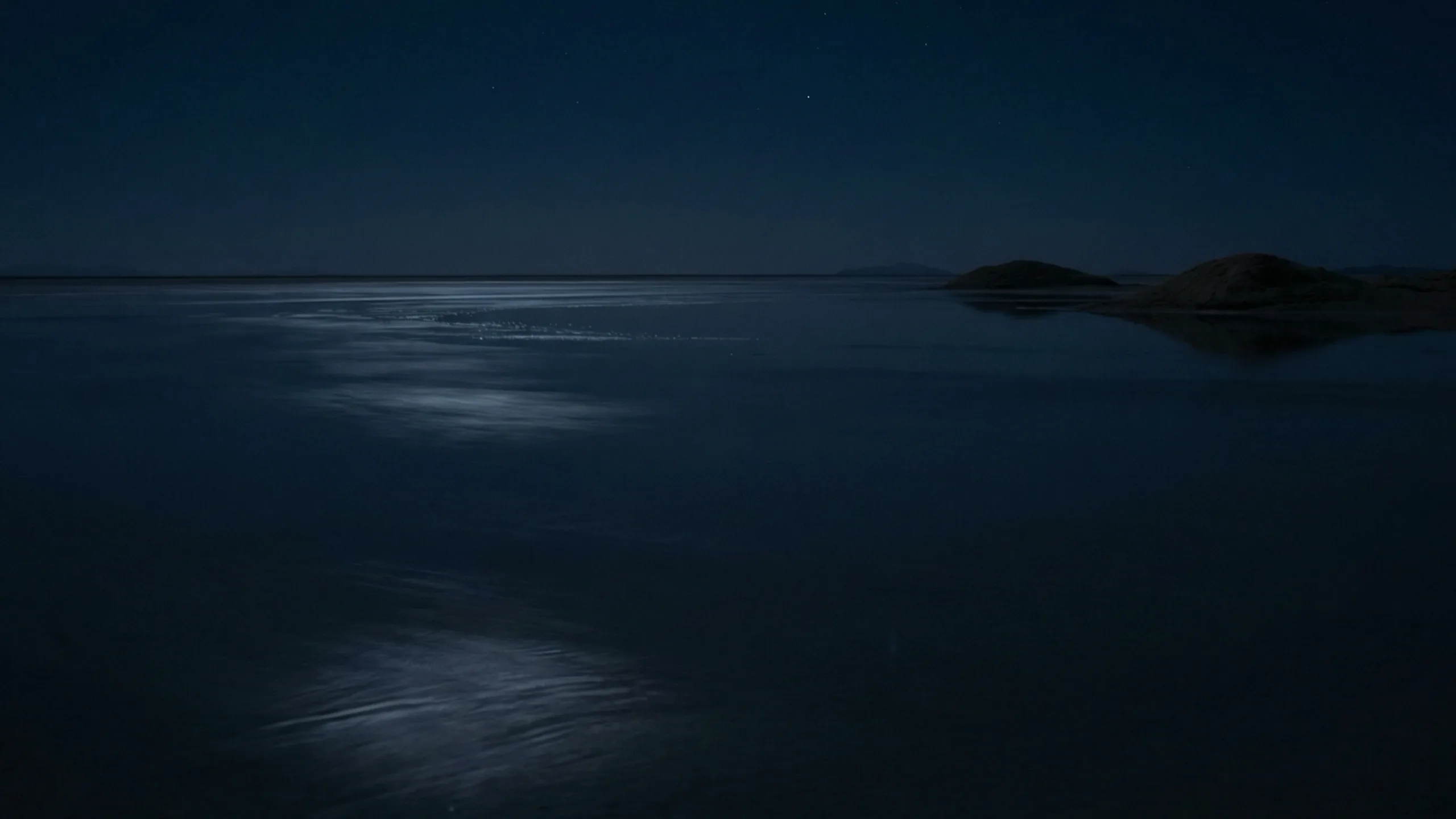 Salar de Uyuni at night, moonlight on the salt flat under a starlit sky